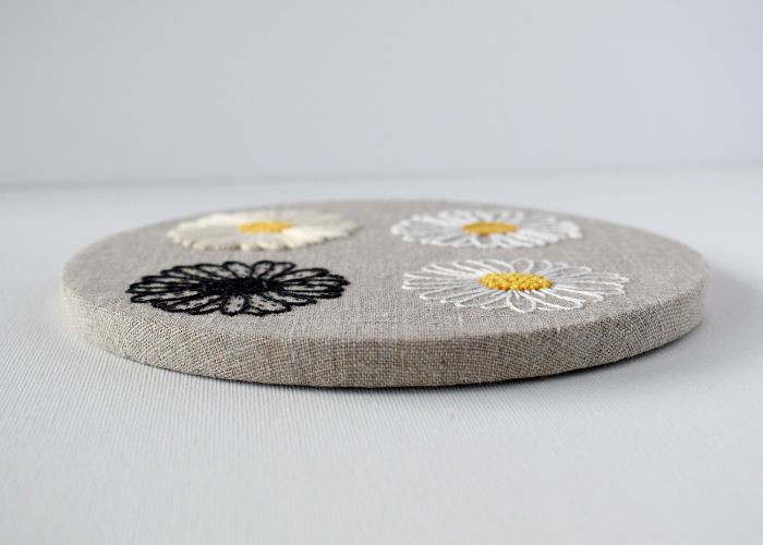 Natürlicher Leinenstoff mit floraler Stickerei, umrahmt ohne den äußeren Stickrahmen